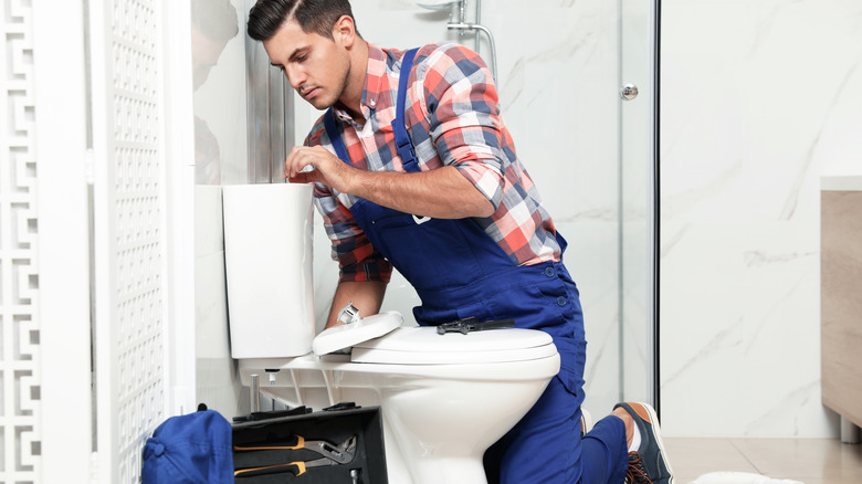 Plumber doing toilet repair