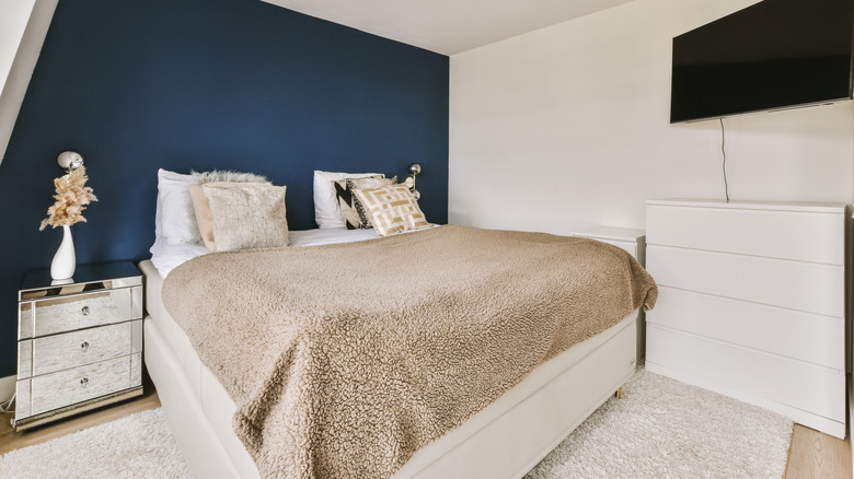 White bedroom with a dark blue accent wall