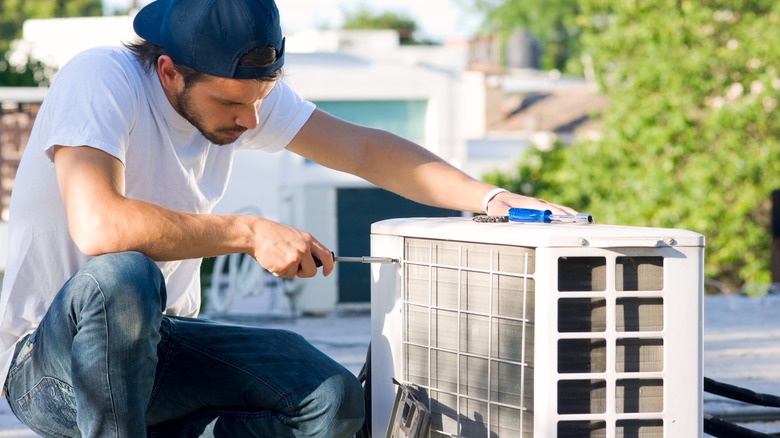 Man servicing or installing and HVAC condenser unit