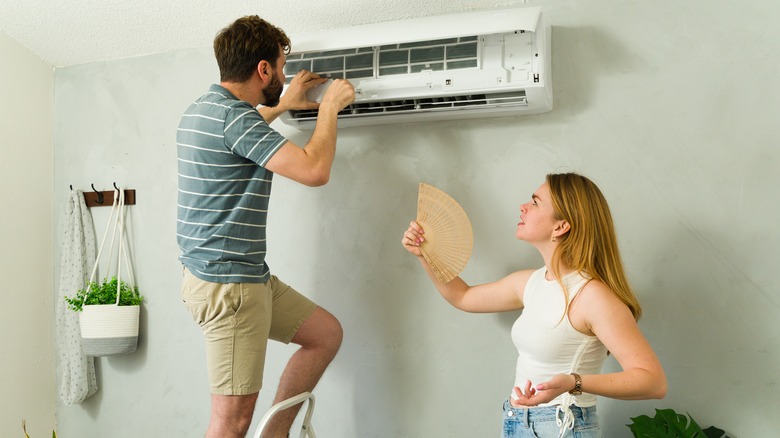 A man installing or repairing a mini-split AC system