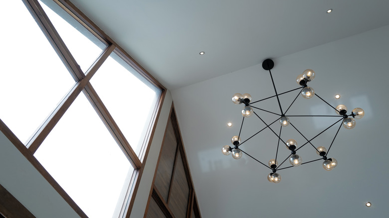 A large black chandelier hanging from a high vaulted ceiling