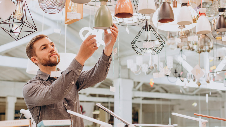 A man browsing chandelier options at a store