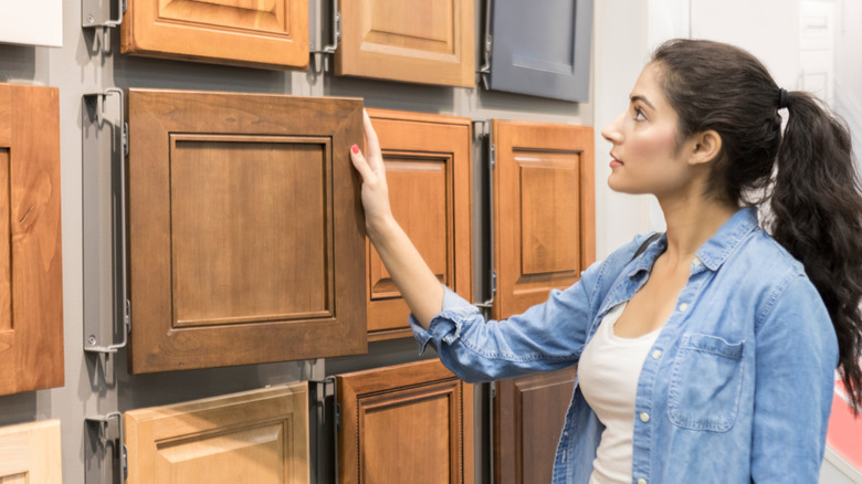 woman shopping wood kitchen cabinets