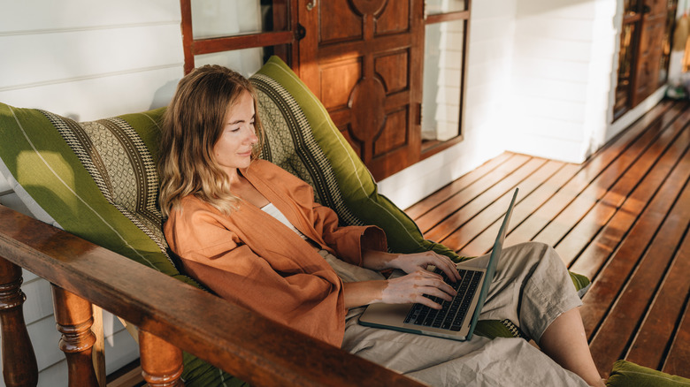Woman on laptop on front porch