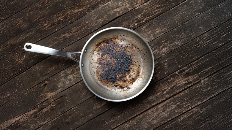 dirty aluminum pan on a dark wooden table