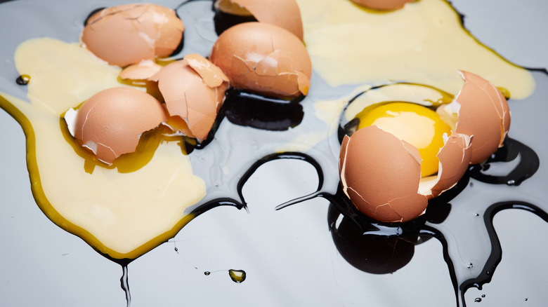 Two eggs smashed on a glossy surface