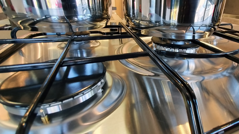 a gas stove top that is sparkling, clean, and shiny