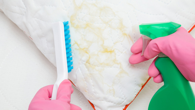 Closeup of yellow-stained pillow with cleaning tools