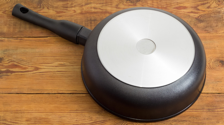 pan with smooth steel base upside down on a wood surface