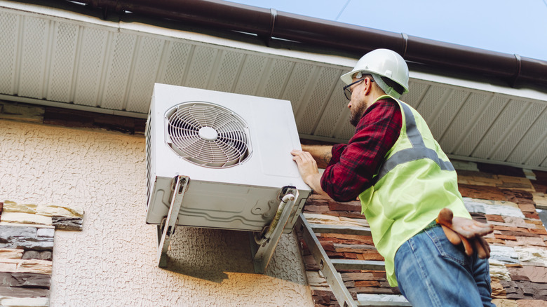 An engineer repairing a heat pump