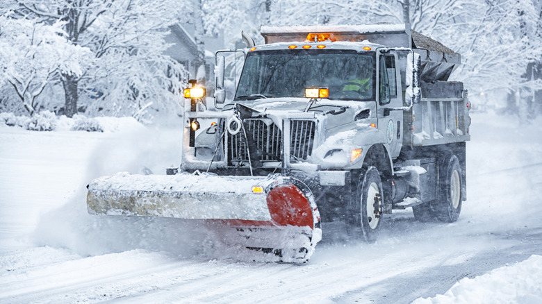 A plow removes snow from a residential street.