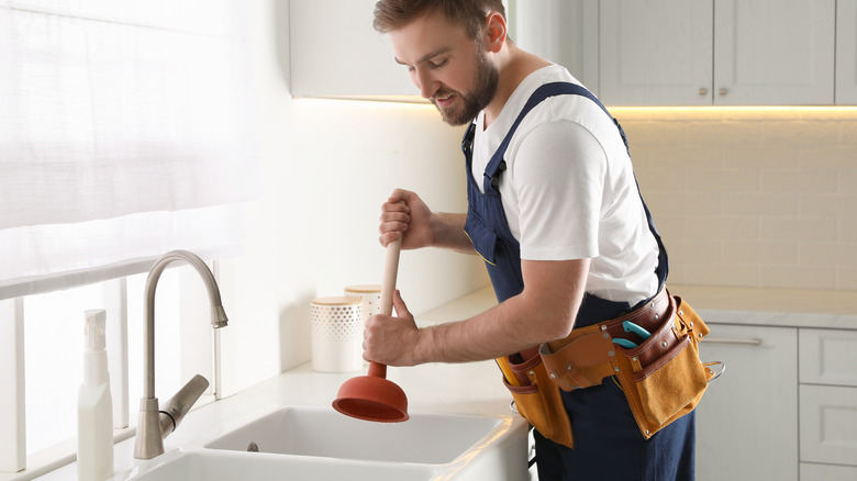 plumber unclogging sink