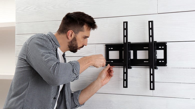 person hanging tv mount