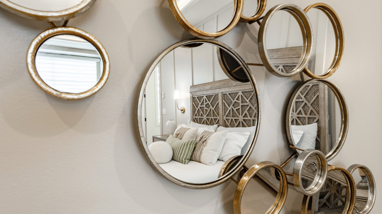 Close-up of multiple small circular mirrors on a bedroom wall