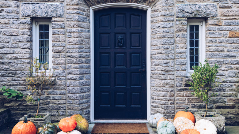 Gray stone home exterior with a black front door