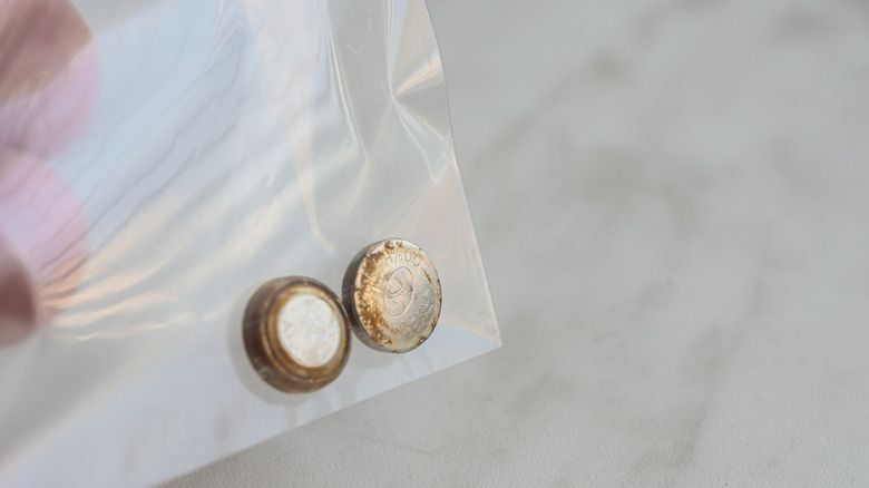 Rusty button batteries in a clear plastic bag