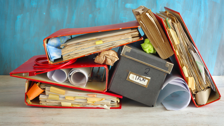 Pile of folders, binders, and a box with important documents