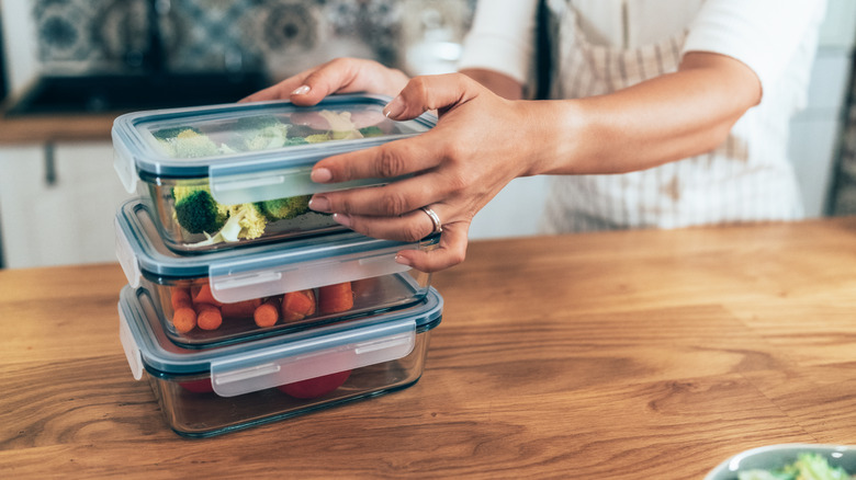A person packs food into an airtight container