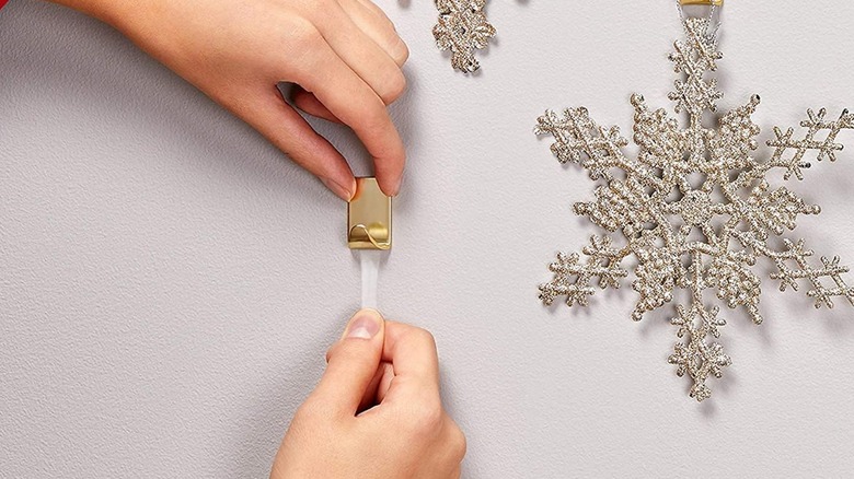 A person pulling a Command strip off the wall