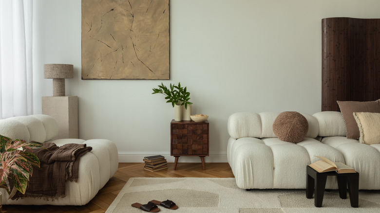Living room with light wood floors, a beige rug, and dark wood accents