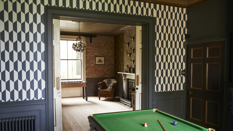 billiards room with geometric wallpaper that doesn't match adjoining room