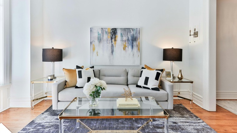 Symmetrical modern living room with glass tables and neutral metallic colors