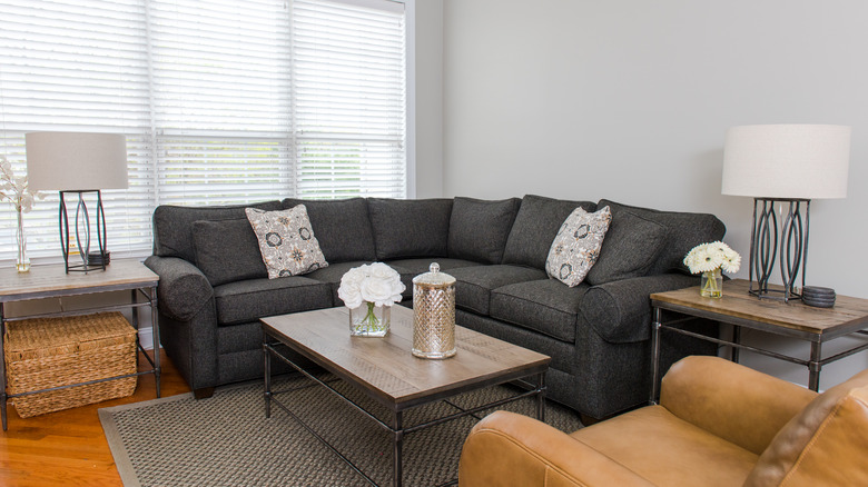 Two end tables in living room with gray couch