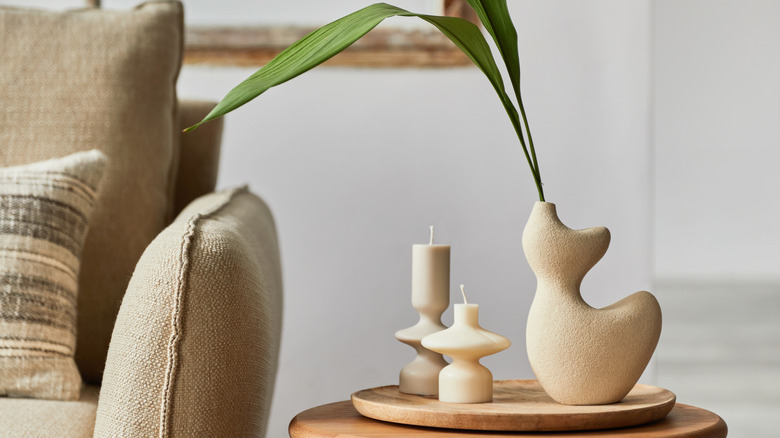 Grouping of two candles of different sizes and a tall vase on end table