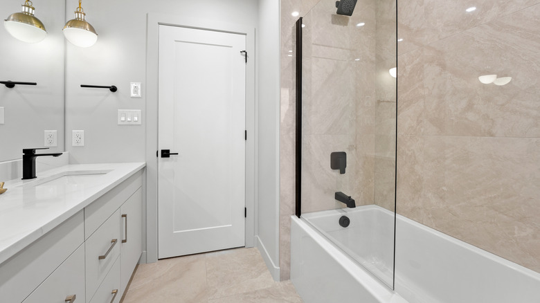 Bathroom with a white door and a glass shower stall.