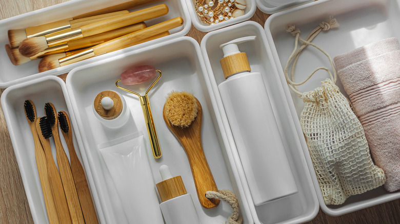 Cosmetics products arranged in white organizers.
