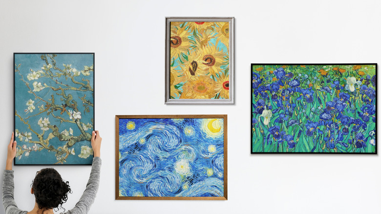 Person arranging posters of popular pieces of artwork on walls of home