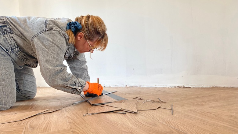 blonde woman cutting vinyl flooring