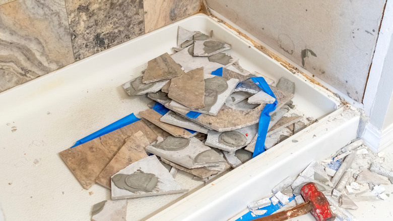 A bathroom shower under construction with broken tiles