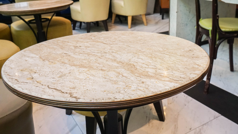 A large marble topped dining table in a store.