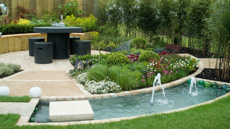 a backyard oasis with a pool, greenery, fences, and table