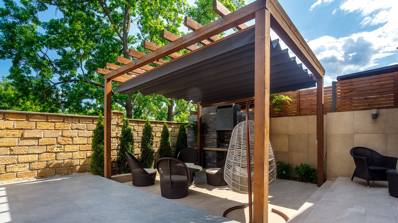 A pergola with a retractable awning on a back patio