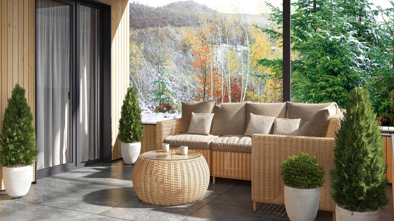 A wicker couch and coffee table in a backyard with mountain views