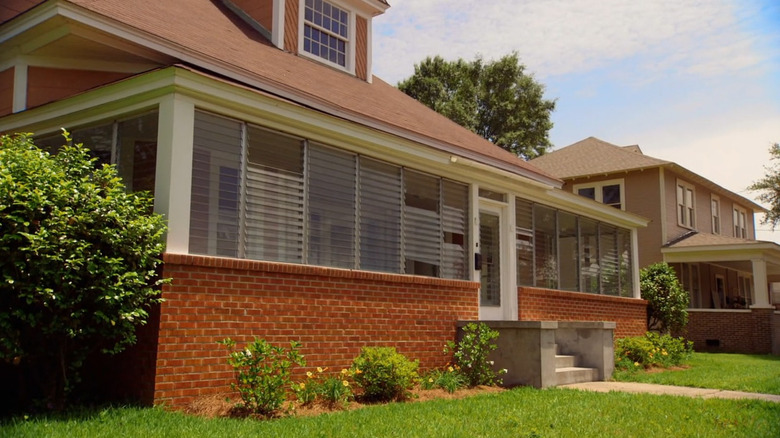 An exterior of a home with an enclosed porch.