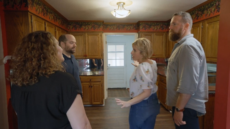 Erin and Ben Napier showing clients an old kitchen.