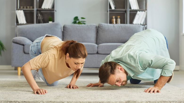 Man and woman smelling carpet for odor