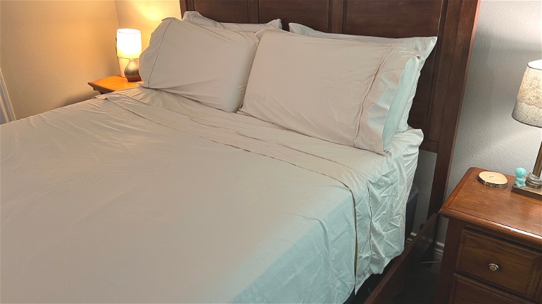 Closeup of wooden bed with beige Bedsure sheets.