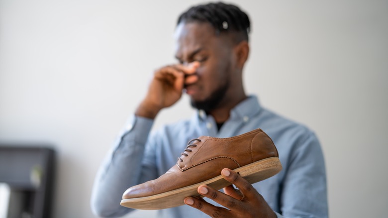 Man holding smelly shoe