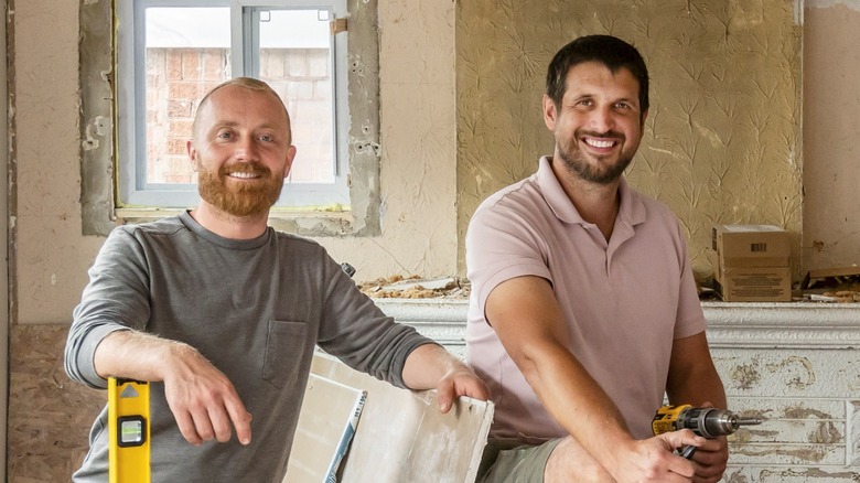 Keith Bynum and Evan Thomas smiling in gutted room