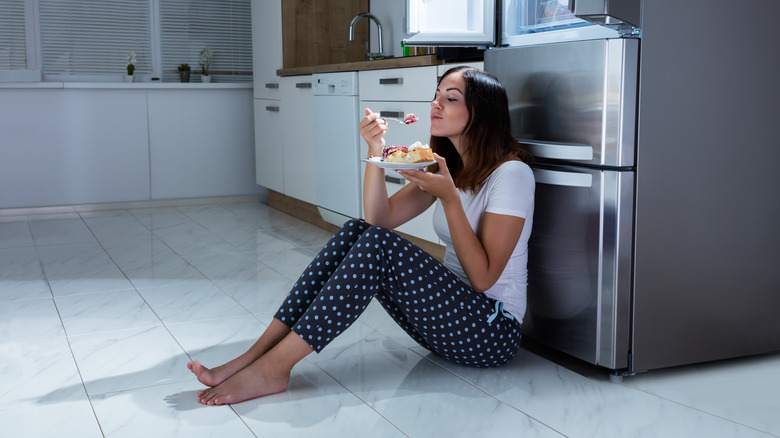 woman eating on tile floor