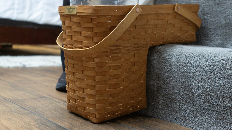 A Longaberger stair basket placed on carpeted staircase.