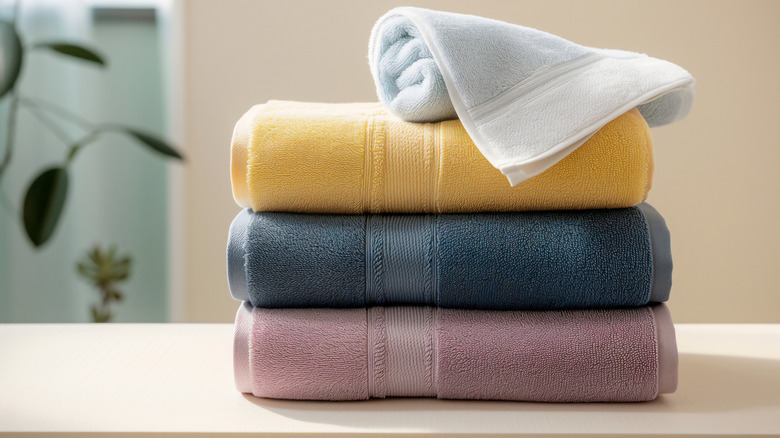 A stack of towels three towels and a washcloth, all with dobby borders.