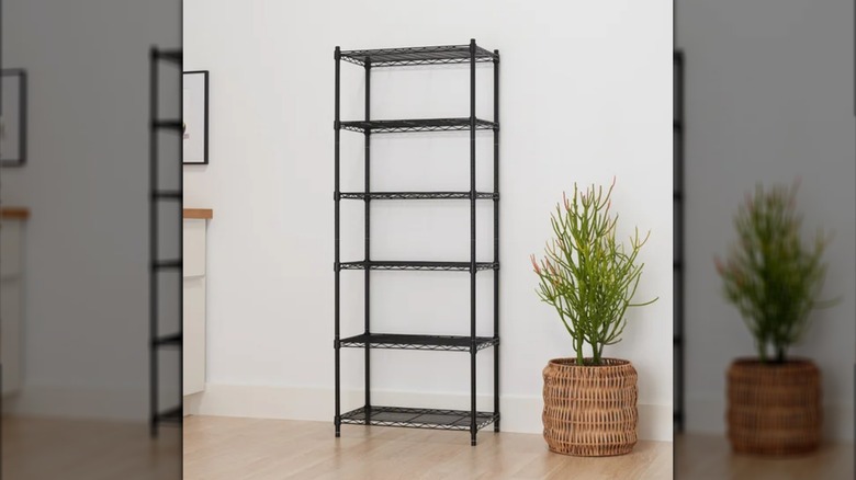 Trinity's 3-Tier Modular Shelving Rack against a white wall next to a plant in a wicker basket