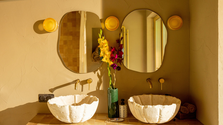 Orange decorative vanity lamps on both sides of two mirrors