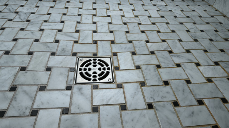 basket weave tile flooring in a shower with a drain