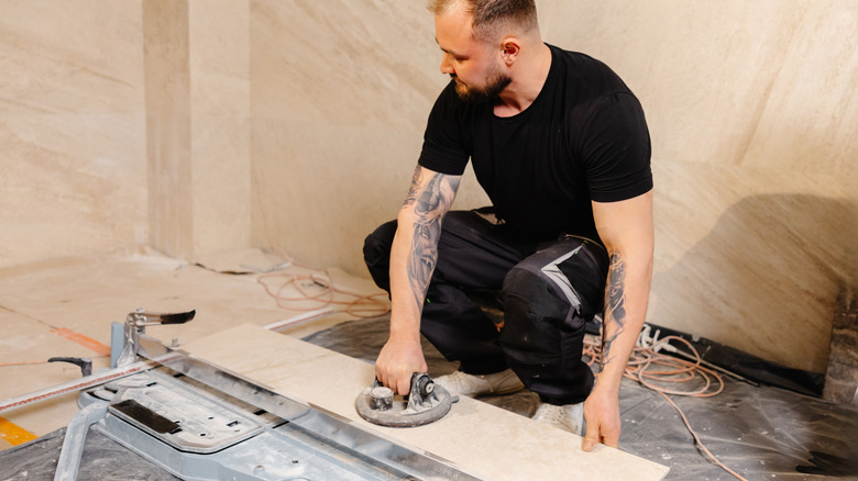 A man installing long tiles in a bathroom